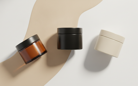 Verschillende pomades met uiteenlopende hold naast een kam op een lichte achtergrond