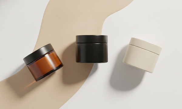 Verschillende pomades met uiteenlopende hold naast een kam op een lichte achtergrond