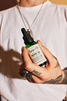 Pomp & Co. Beard Oil - close-up van flesje in hand met leesbaar etiket